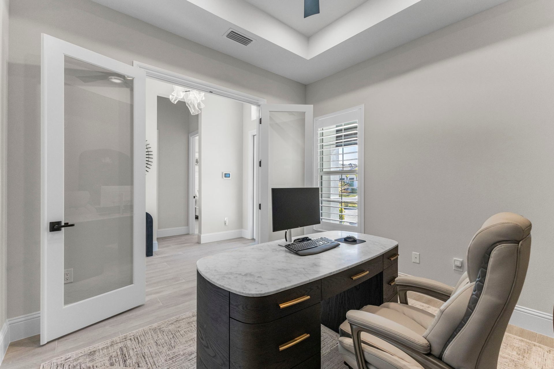 Home office with custom desk, leather chair and glass doors