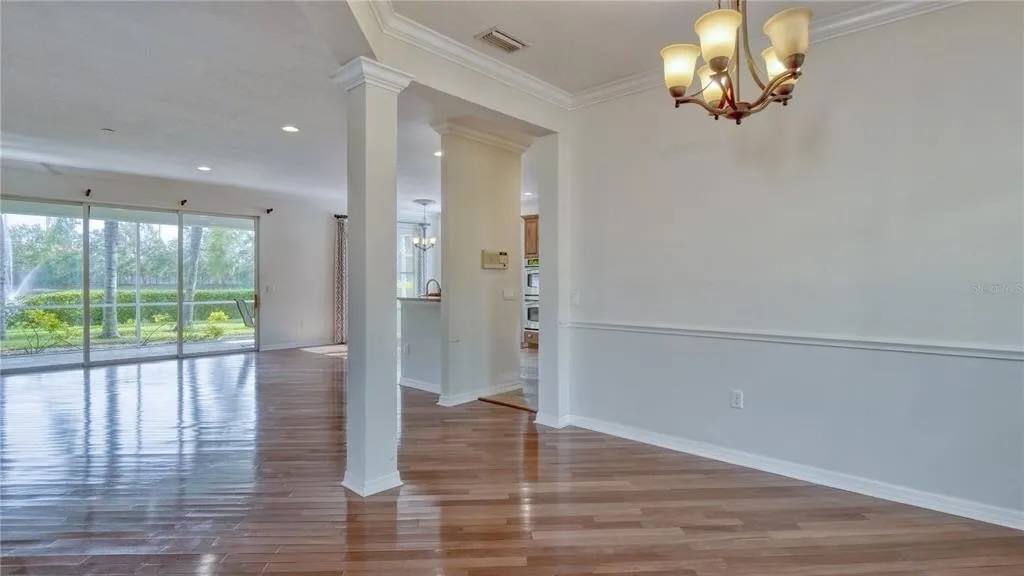 Before — dining and living area with original wood flooring and millwork
