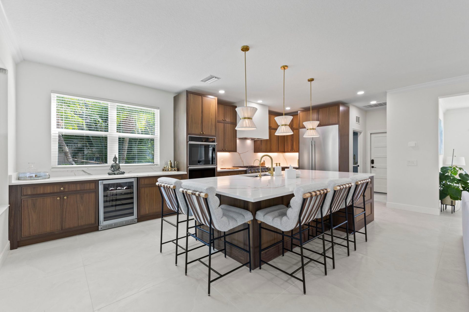 Inset frame walnut kitchen with large quartz island, brass pendants and counter seating