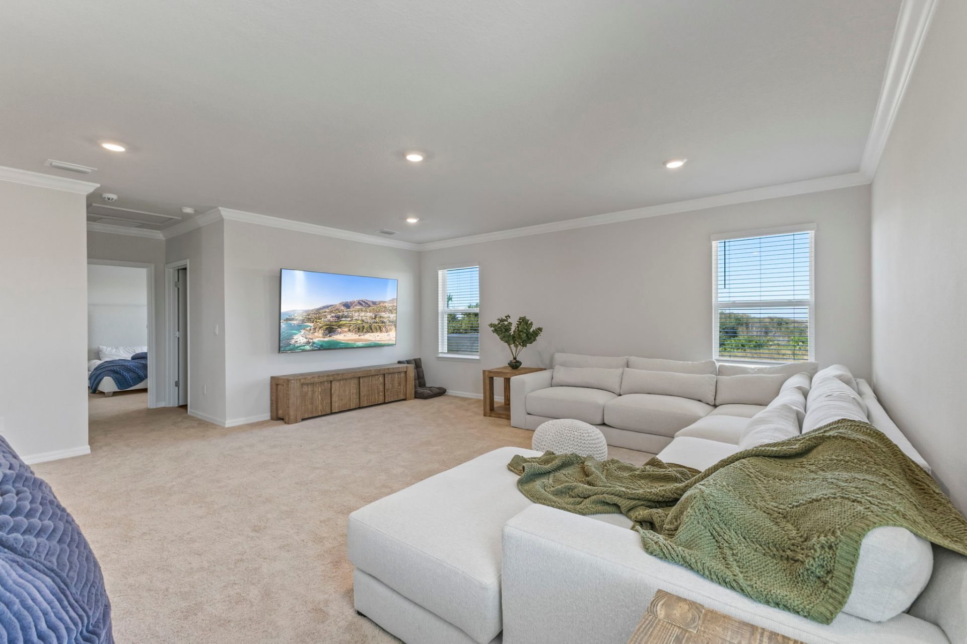 Upstairs bonus room with sectional sofa, console and mounted television