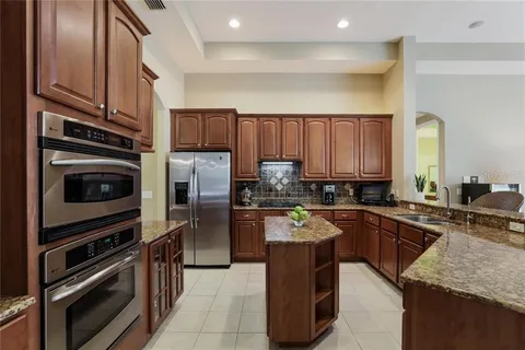 Before — original Greenbrook kitchen with dark cherry cabinetry and small island