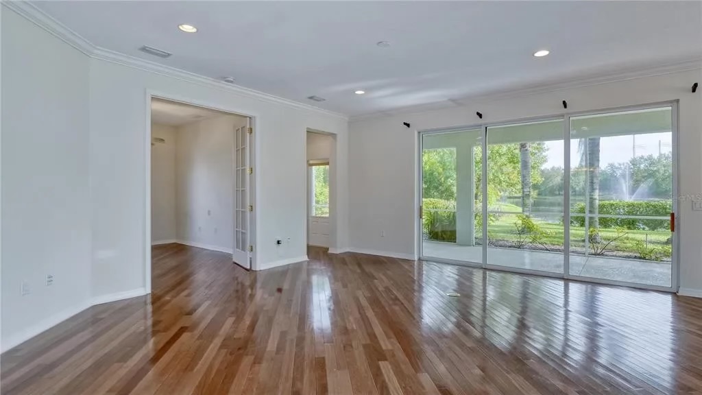 Before — great room with sliding doors opening to the lake and fountain view