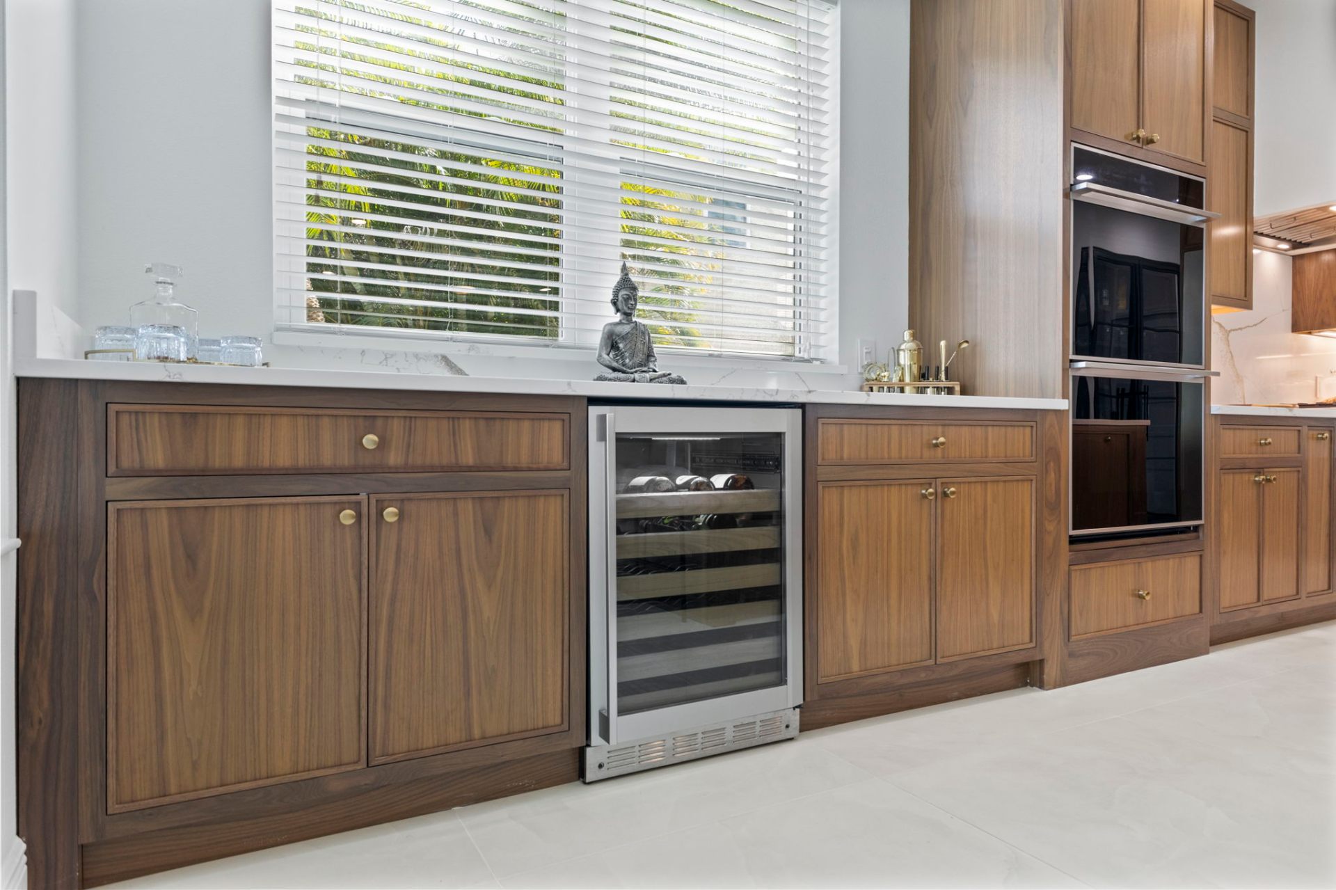 Custom walnut bar with built-in wine refrigerator and quartz counter