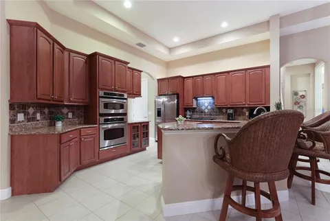 Before — original cherry cabinetry and granite countertops