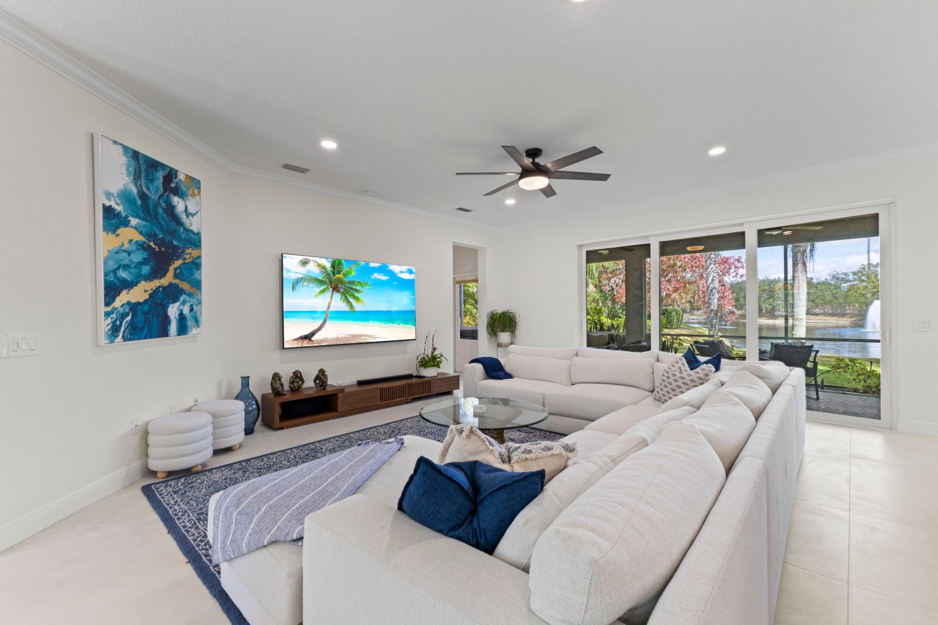 Living room overlooking the lake with curated furnishings and walnut media console