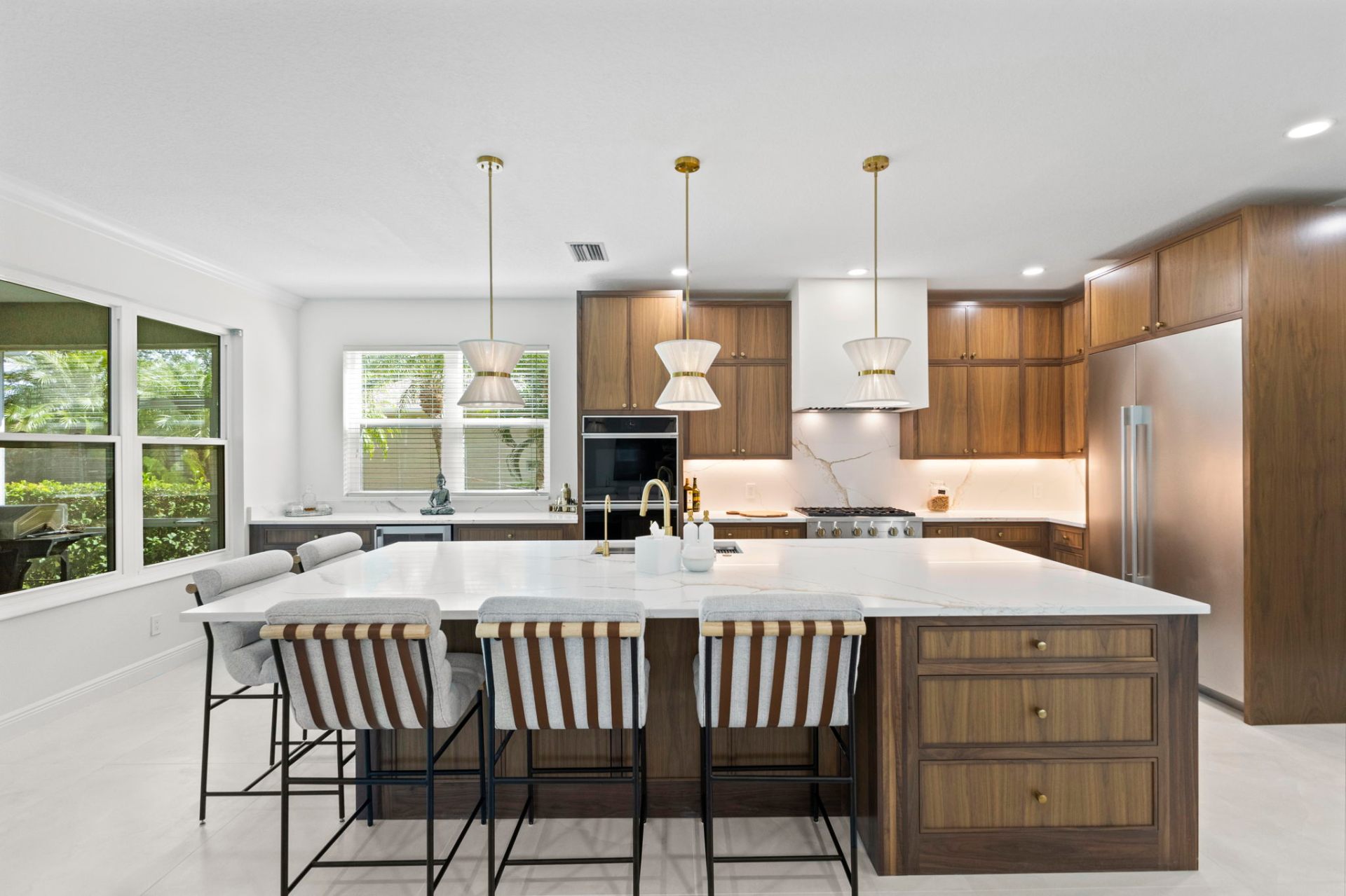 Custom solid walnut inset kitchen with large quartz island and brass pendants