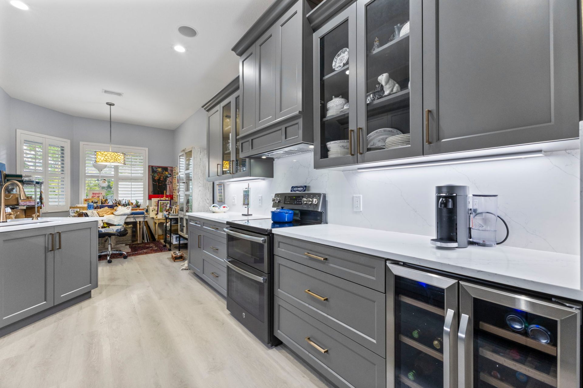 River Club kitchen remodel — Gauntlet Gray custom cabinetry with glass-front display uppers and champagne bronze hardware