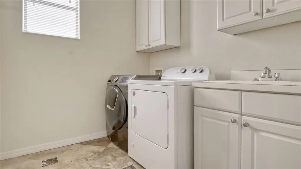 Before — original laundry room with builder-grade cabinetry
