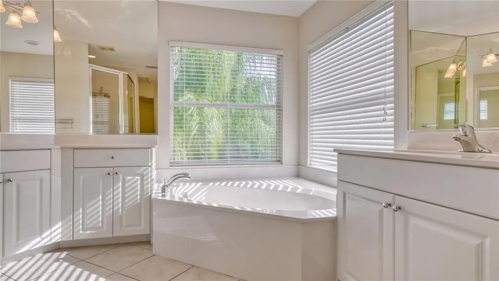 Before — original primary bathroom with garden tub and dual vanities