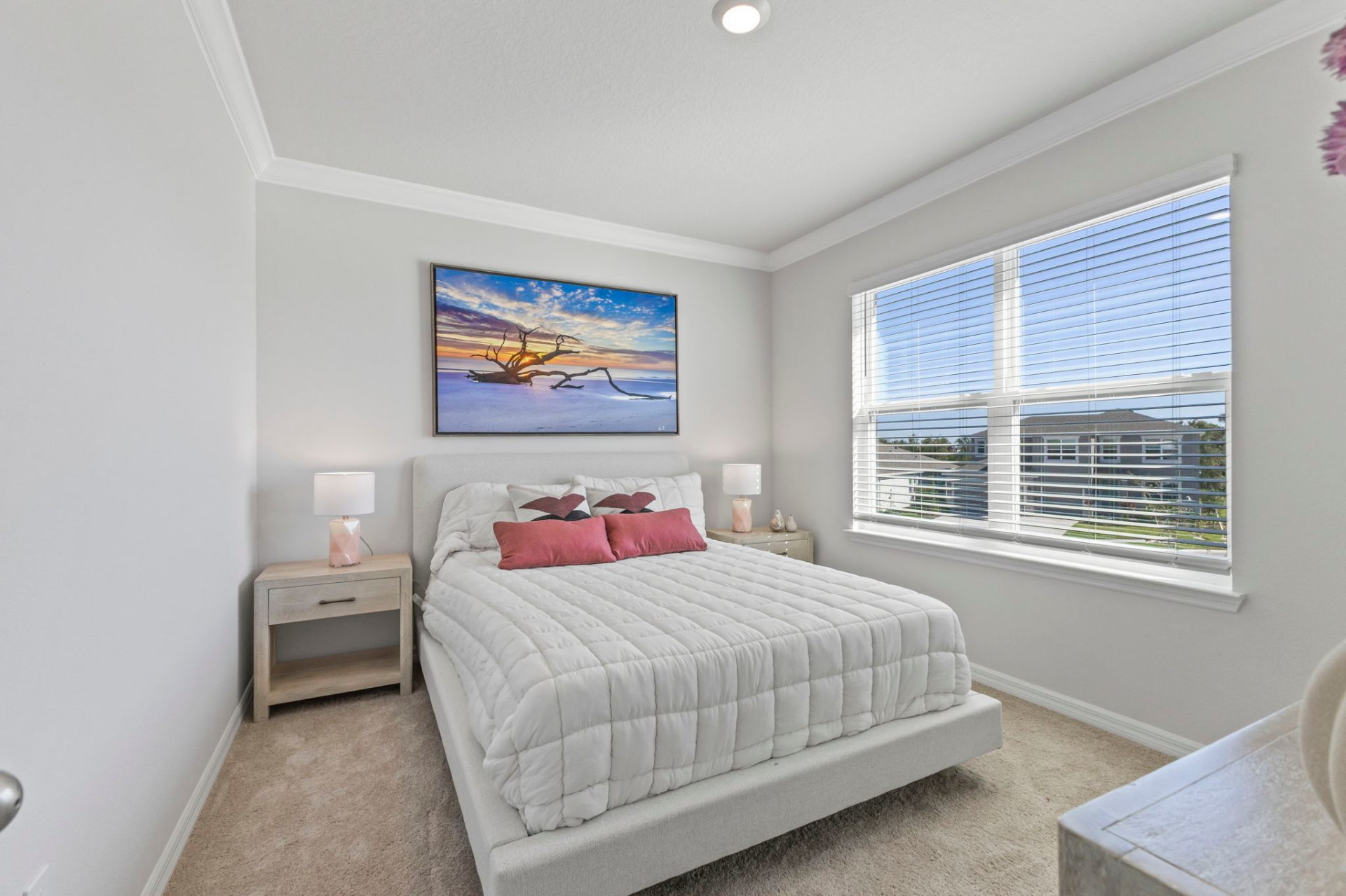 Guest bedroom with coastal artwork and custom bedside styling