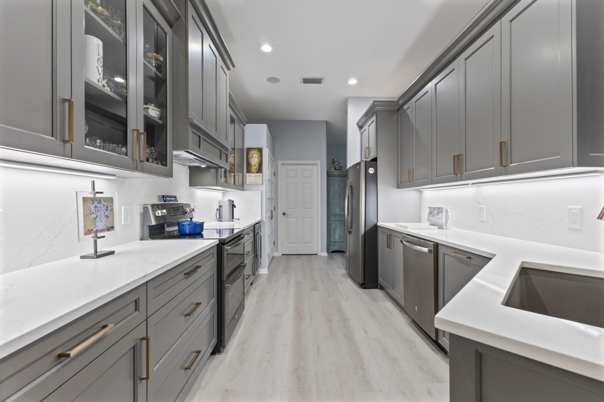 Custom Gauntlet Gray shaker cabinetry with champagne bronze pulls and quartz backsplash