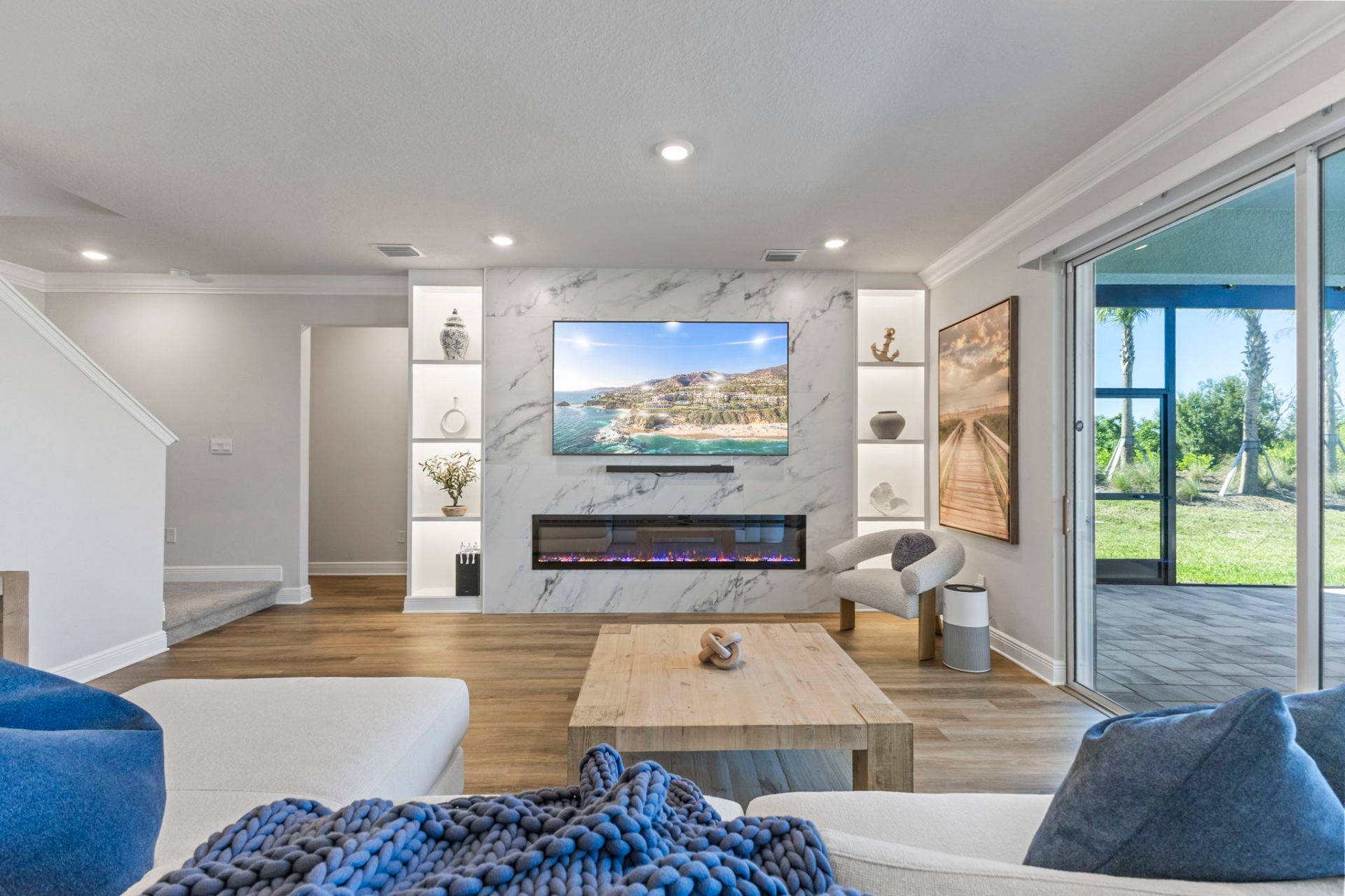 Open living room with custom marble feature wall and lake-view sliding doors
