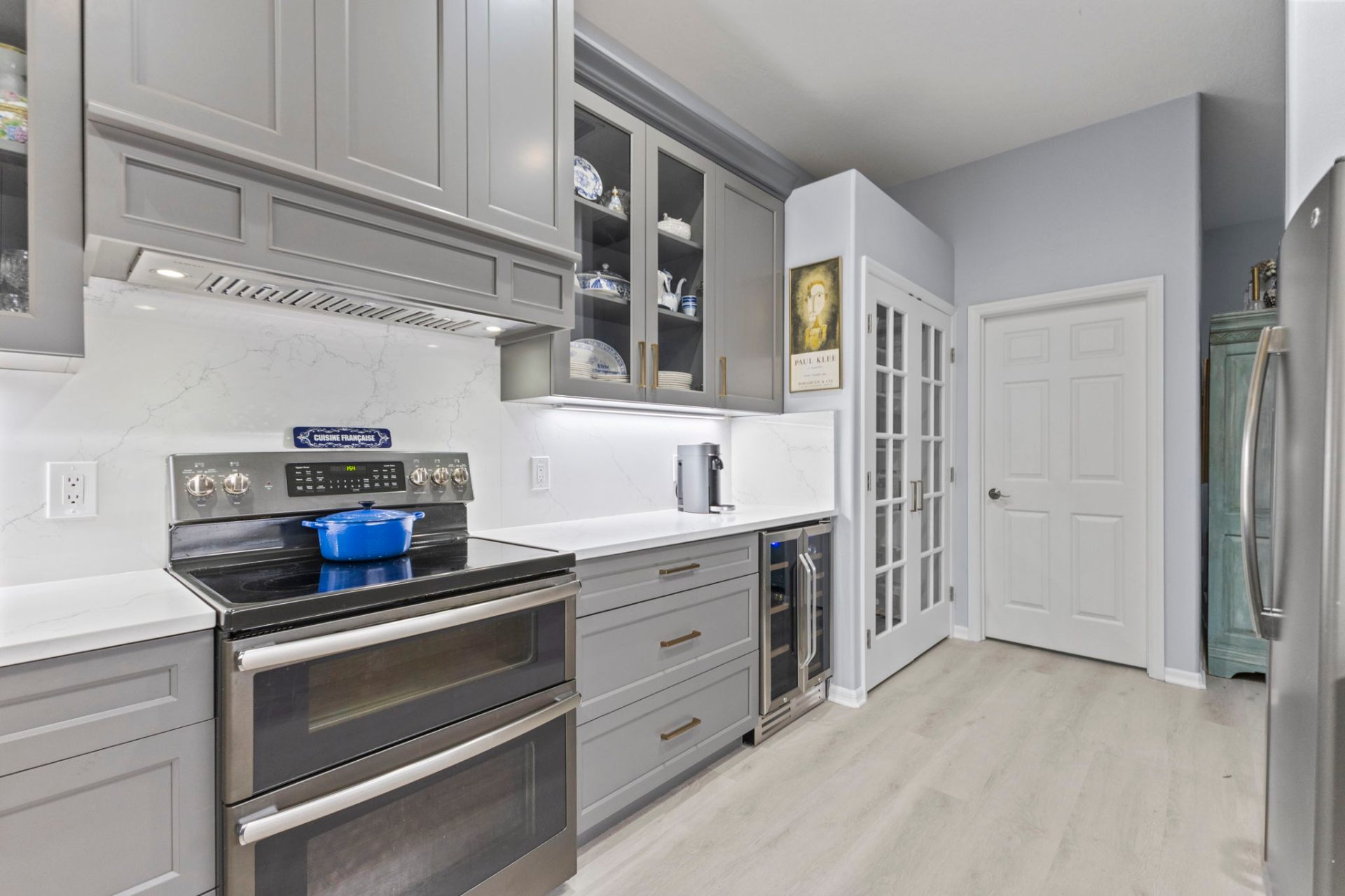 Decorative range hood, glass-front display cabinets and integrated wine refrigerator