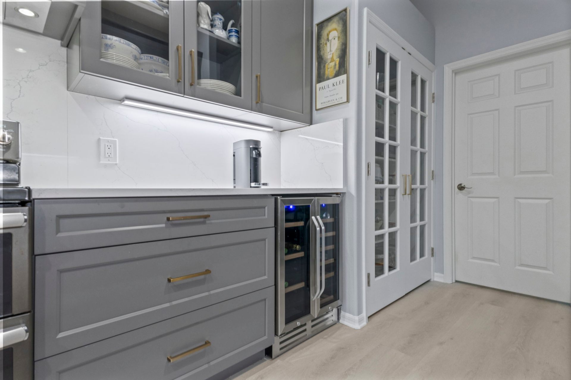 Built-in wine refrigerator, quartz countertops and French-door pantry detail
