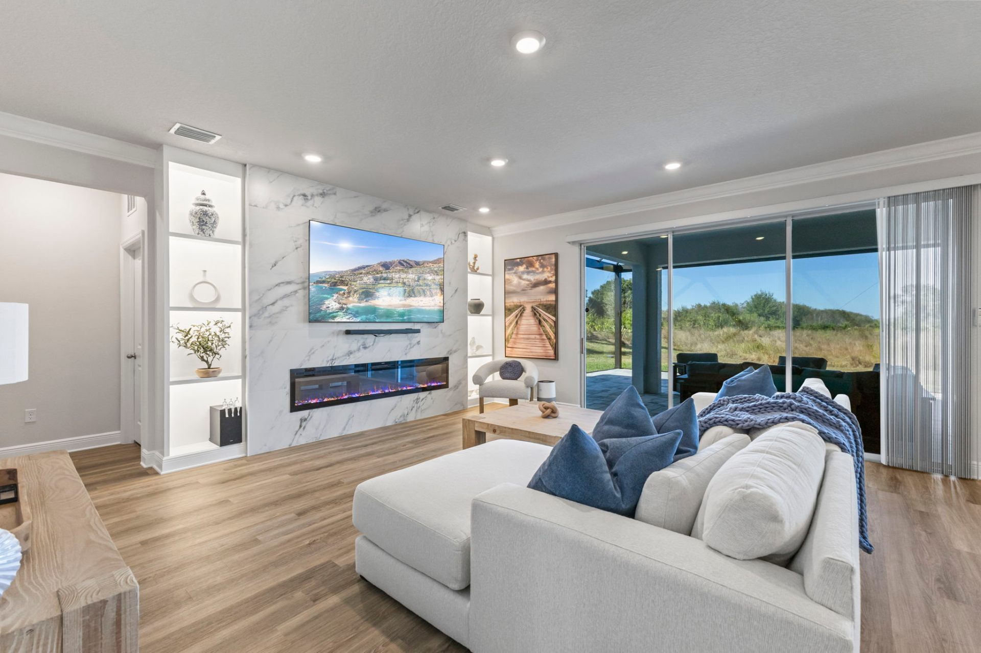 Wide view of the custom marble entertainment wall with built-in shelving and linear fireplace