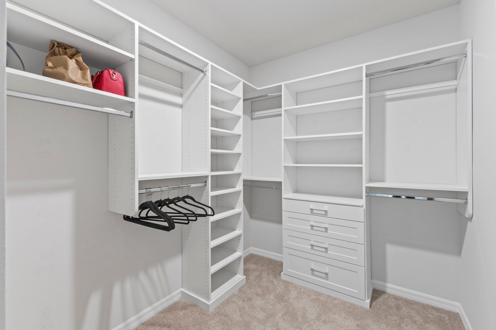 Custom walk-in closet with built-in shelving, drawers and integrated hanging