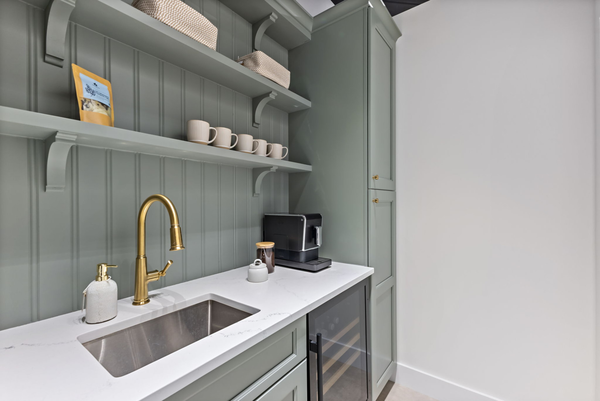 Pantry coffee station with brass faucet, open shelving and tall custom cabinetry