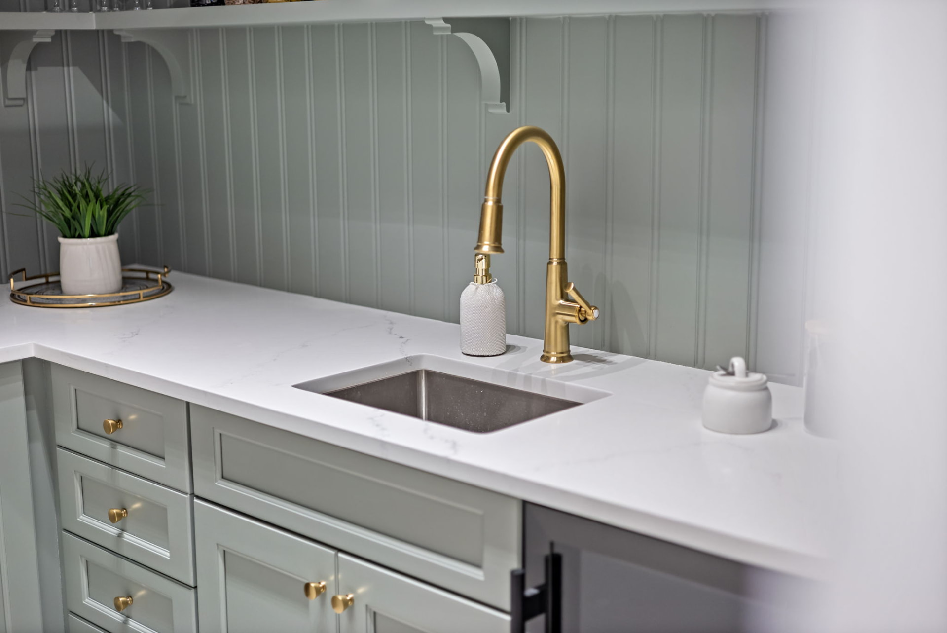 Pantry counter with prep sink, built-in wine refrigerator and styled quartz surface