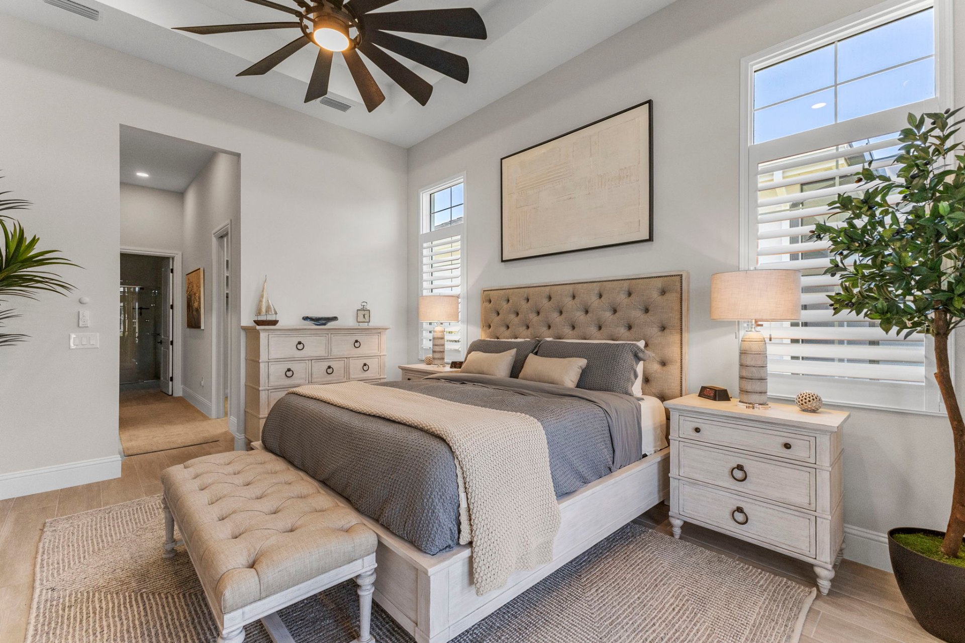 Primary bedroom with tufted upholstered headboard and bench
