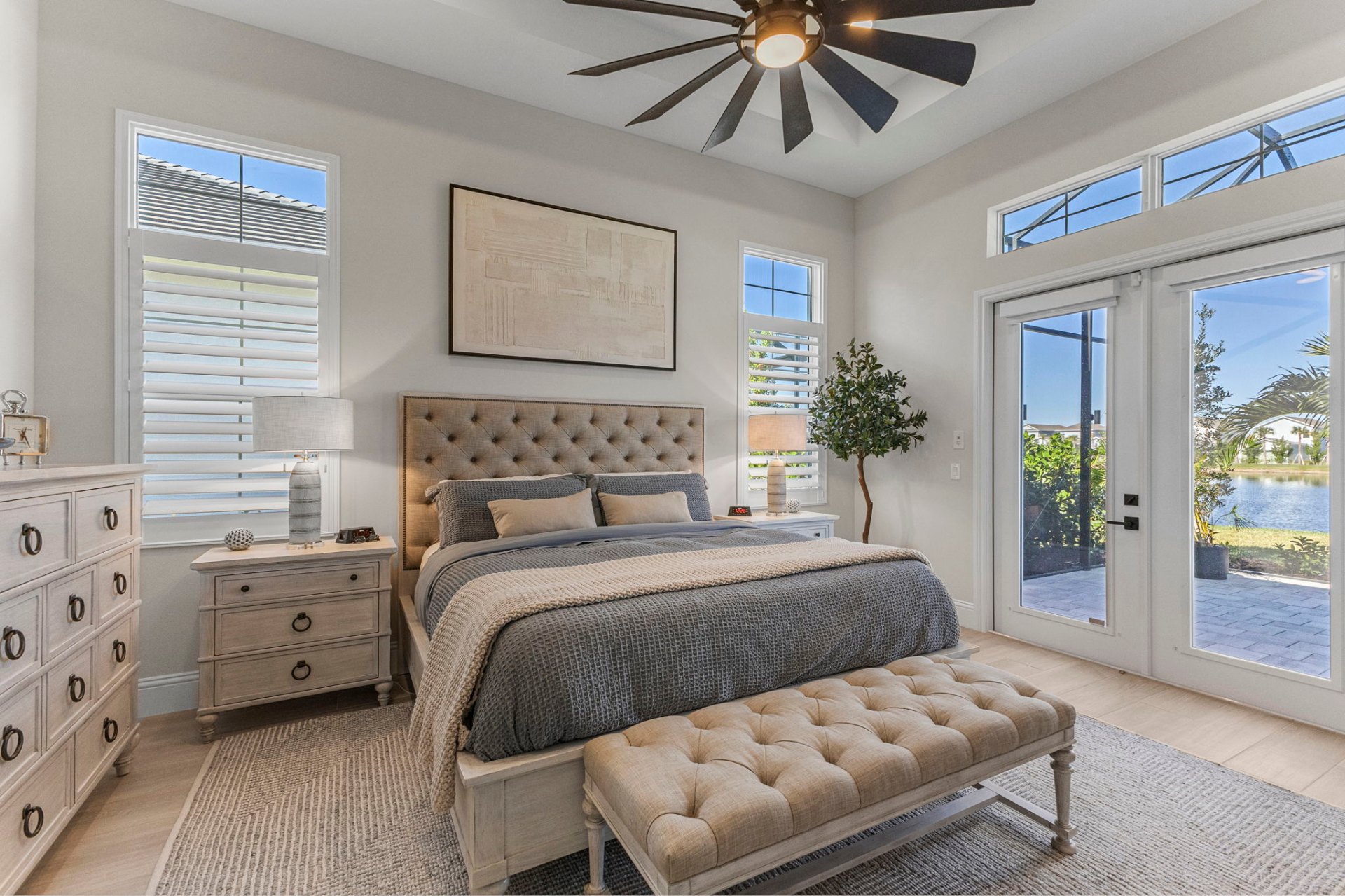 Primary bedroom with French doors opening to the lanai and lake