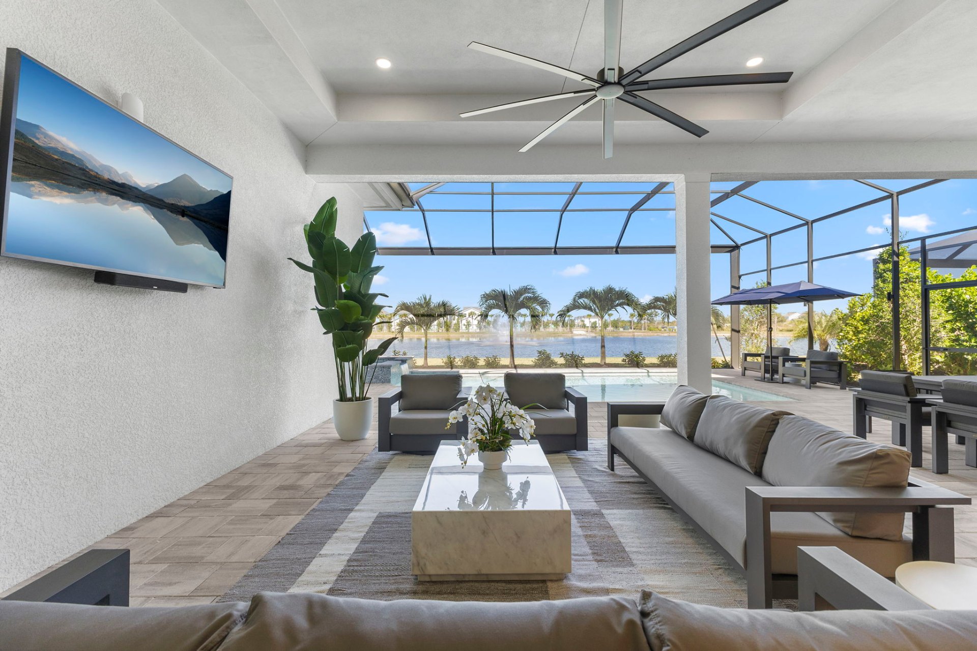 Lanai living area with lake views, outdoor TV and designer seating