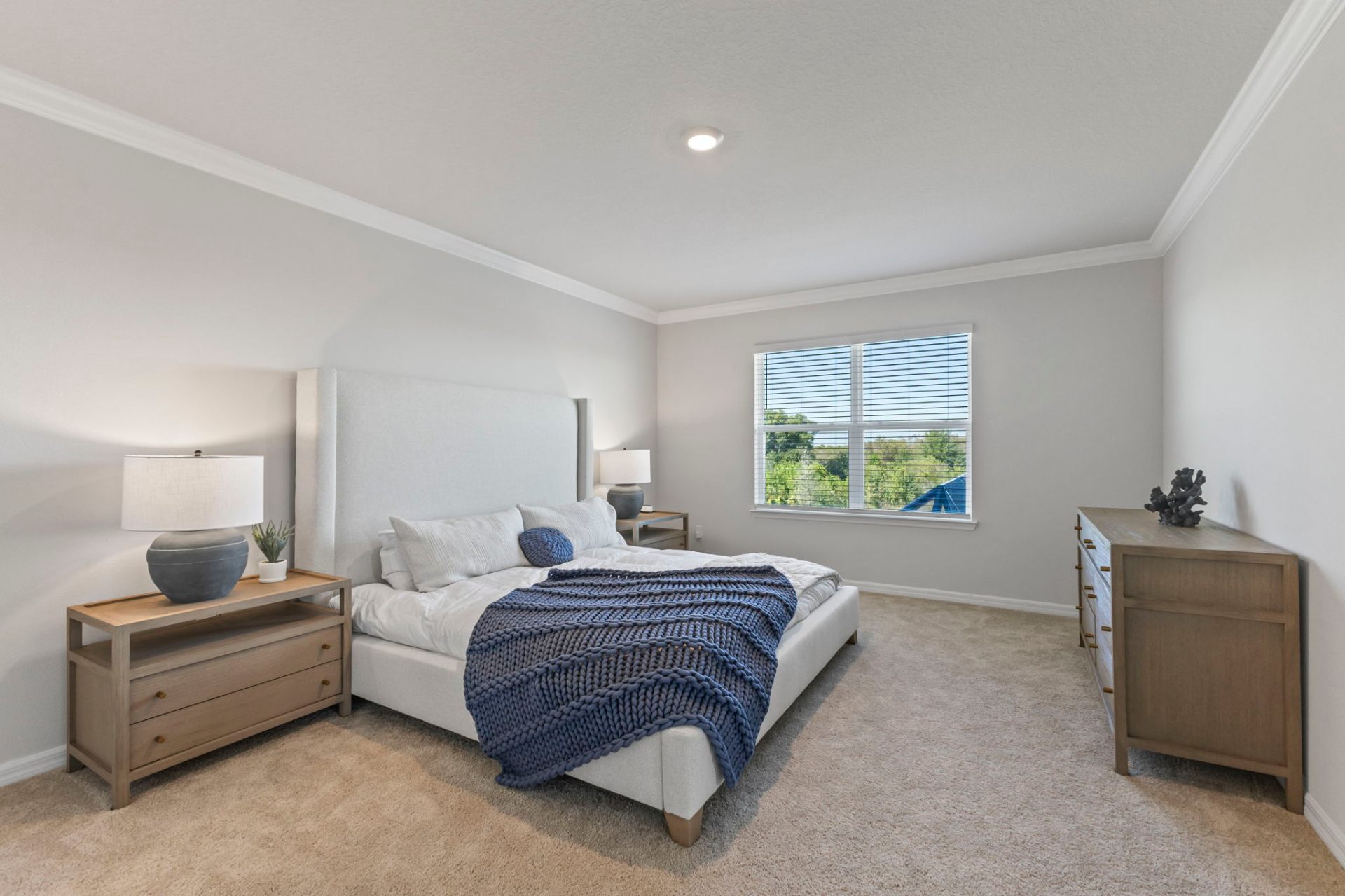 Primary bedroom with upholstered headboard, custom nightstands and coastal accents