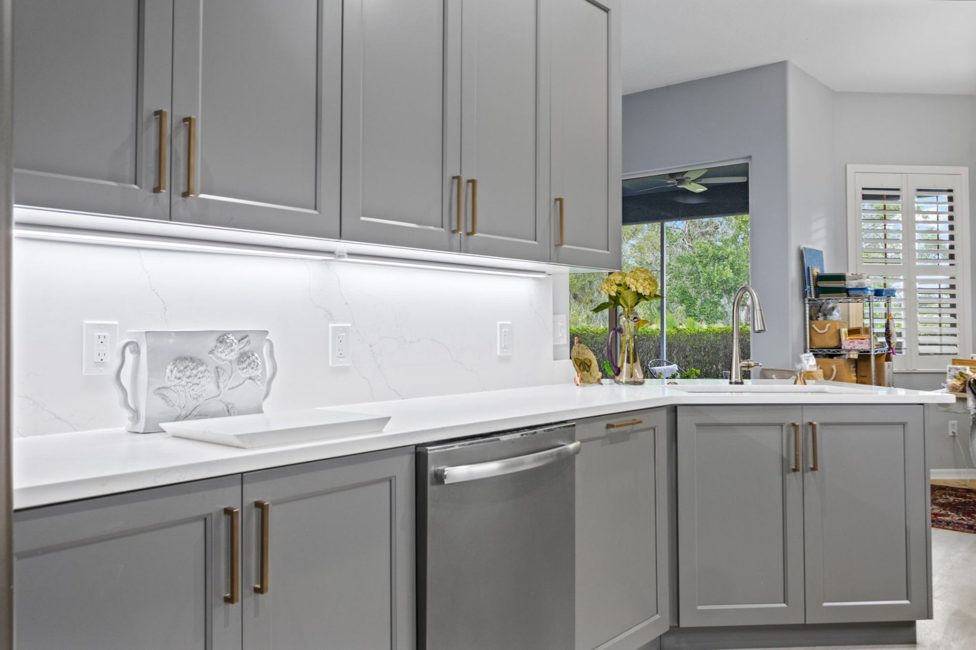 Custom Gauntlet Gray base cabinetry with quartz countertop and full-height backsplash
