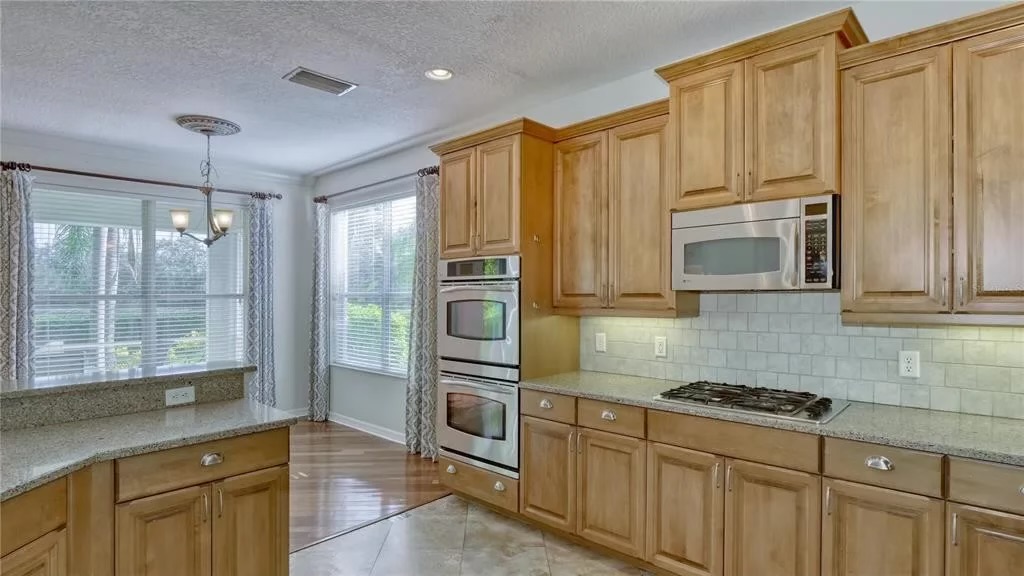 Before — original maple kitchen with double wall oven and gas cooktop