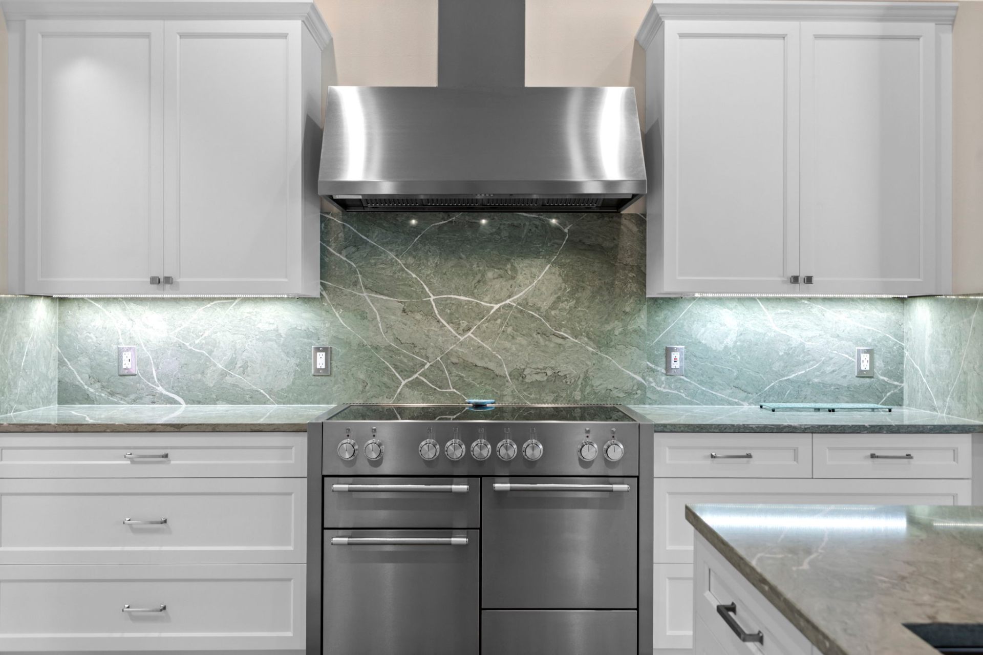 Professional range and full-height natural stone backsplash