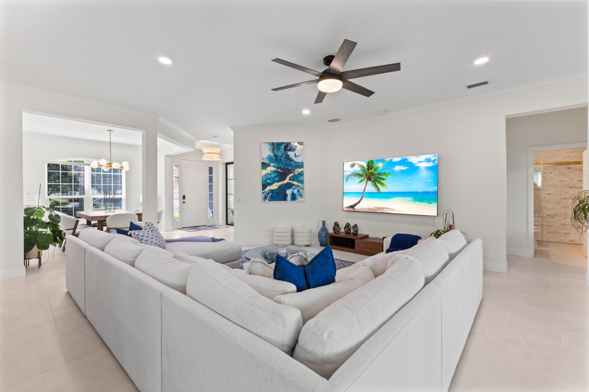 Living room with large wall-mounted TV, custom artwork and ocean-inspired styling