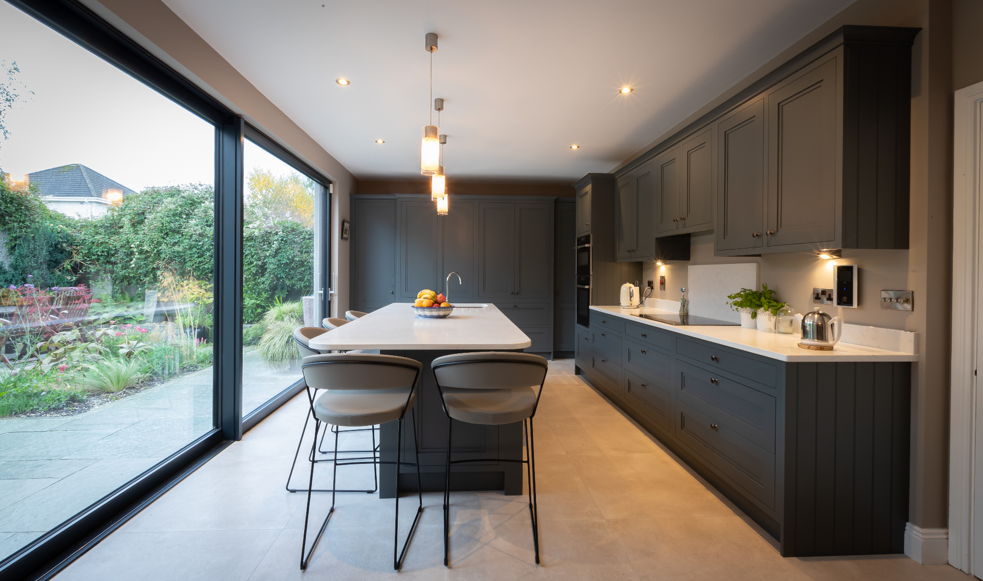 Dark grey bespoke kitchen island with marble-style countertop and garden views — Hepburn Downpipe by Brenton Gold
