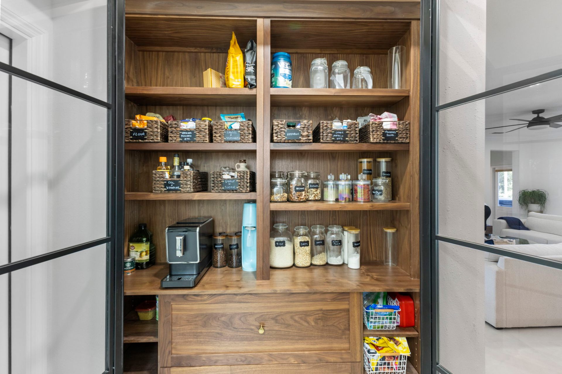 Interior of the custom solid walnut pantry with built-in coffee station and curated jars