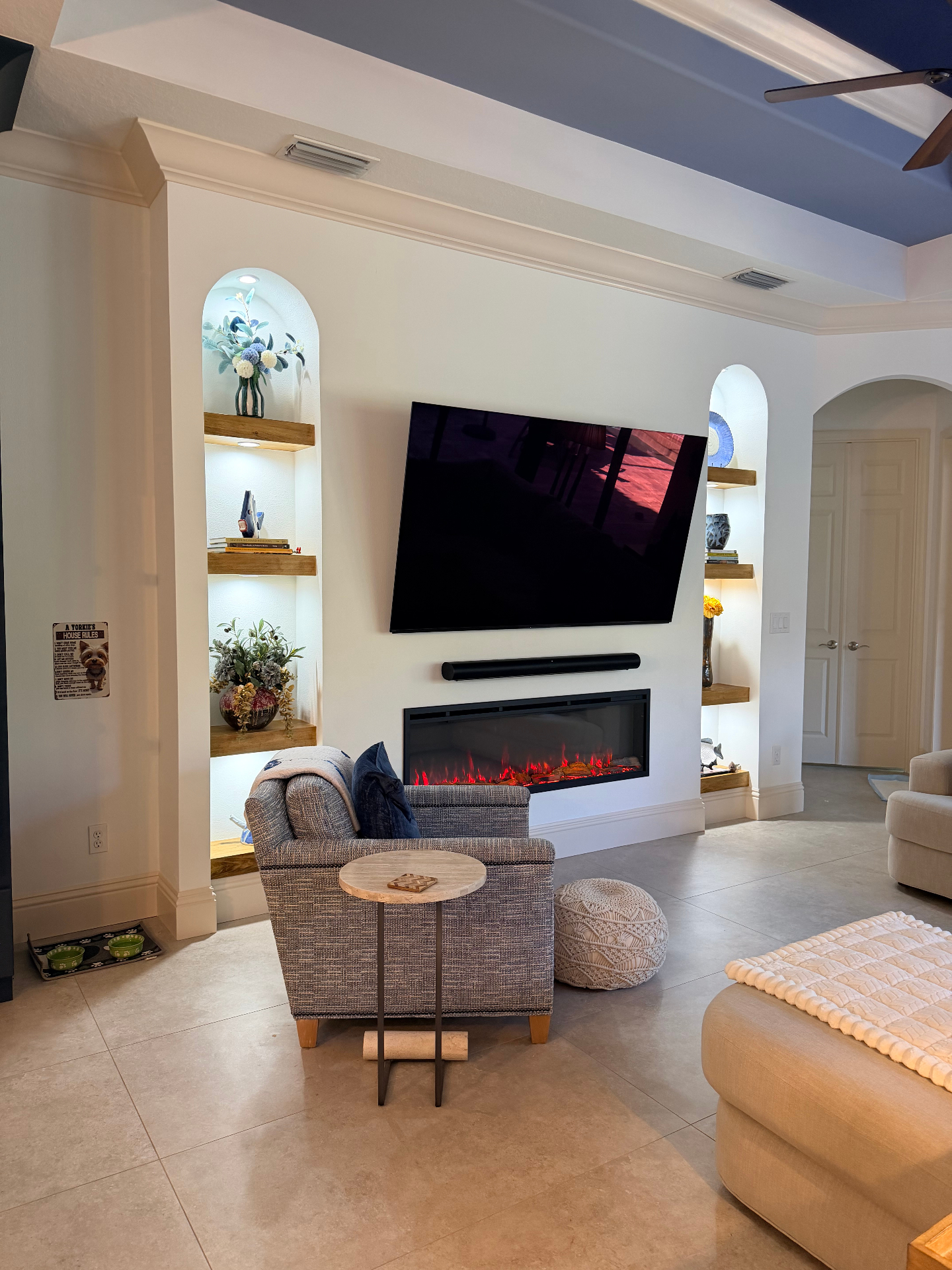 Custom built-in feature wall with arched alcoves, handcrafted wood shelves and integrated electric fireplace