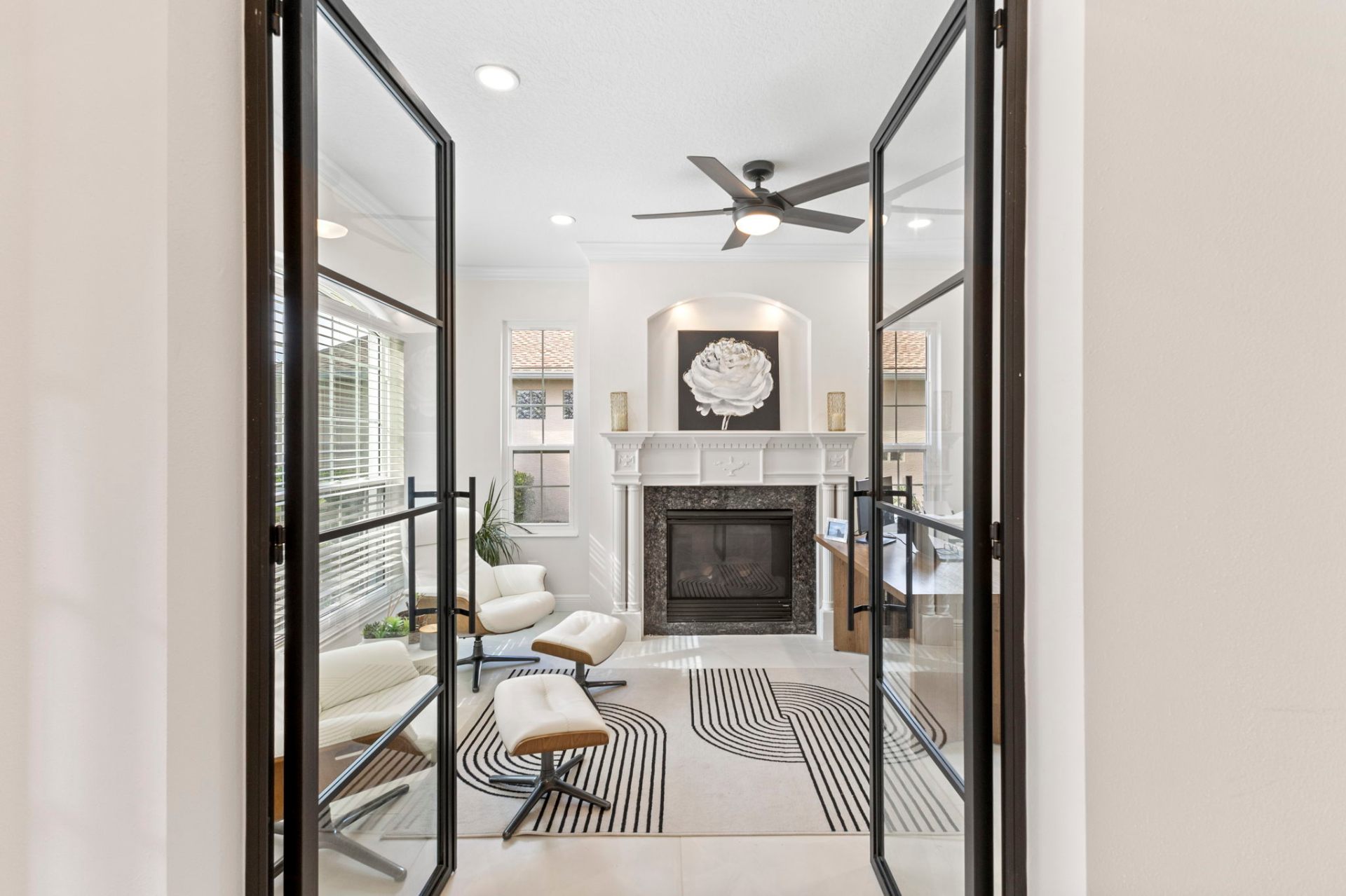 Black aluminum-framed glass French doors opening to the custom home office